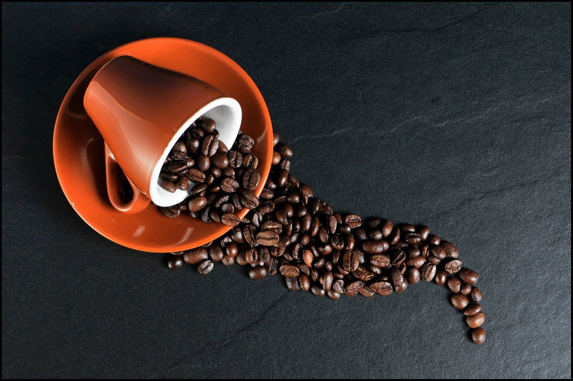 Coffee beans spilling out of a mug