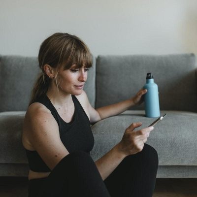 Woman looking at her phone post-workout
